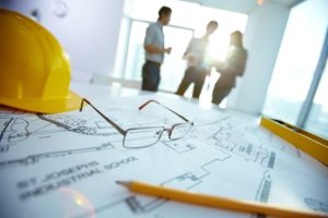 Engineering objects Image of engineering objects on workplace with three partners interacting on background